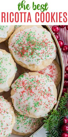 christmas cookies with white frosting and sprinkles in a metal pan on a table