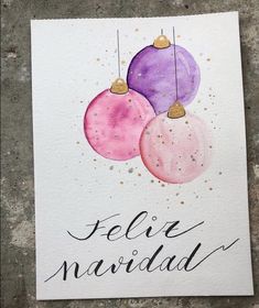 a card with three christmas ornaments hanging from it's sides and the words feliz navidad