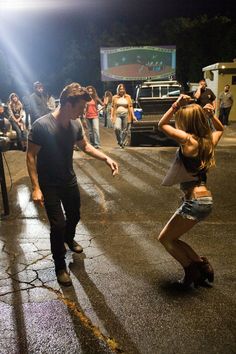 two people dancing in the street at night