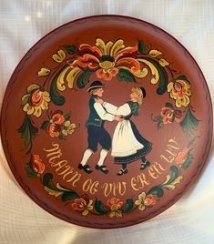 a decorative plate with an image of a man and woman holding each other's hands