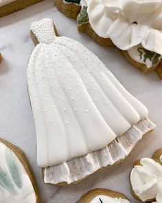 some cookies are laying on a table with white icing and decorated cookie molds