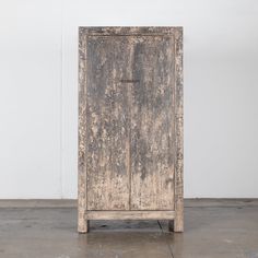 an old wooden cabinet with peeling paint on the doors and bottom part of it's door