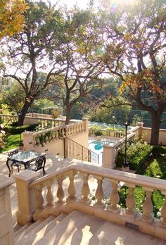 an outdoor patio with table and chairs next to trees