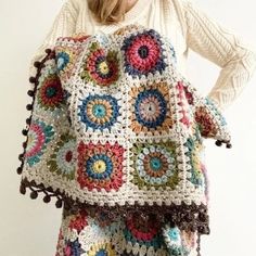 a woman wearing a multicolored crochet granny bag