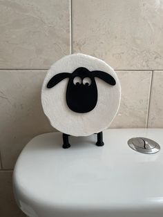 a white toilet with a black sheep on it