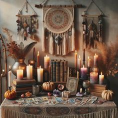 a table topped with lots of candles next to books and other items on top of it