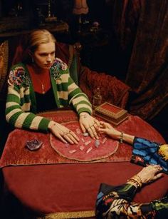 two women sitting at a table with their hands together