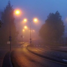 a foggy street with traffic lights on it