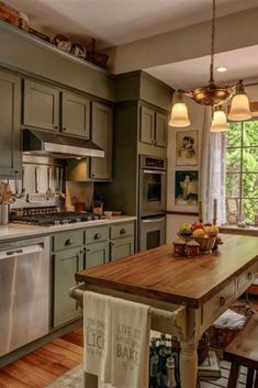 a kitchen with green cabinets and wood floors