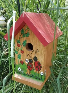 a wooden birdhouse with ladybugs painted on it