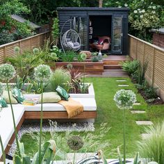 a small garden with lots of plants and furniture in it's back yard area