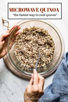 two hands holding a spoon over a bowl filled with oatmeal and granola