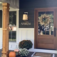 the front porch is decorated with flowers and pumpkins