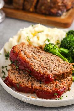 meatloaf and mashed potatoes on a plate with broccoli in the background