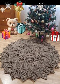 a teddy bear sitting next to a christmas tree with presents on the floor and a crocheted doily