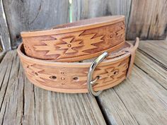 a pair of leather belts sitting on top of a wooden bench