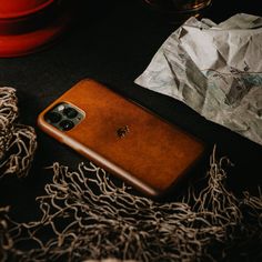 a brown leather case sitting on top of a table next to some paper and glasses