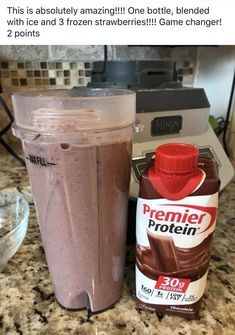 a blender sitting on top of a counter next to a bottle of protein drink