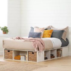 a bed with storage drawers underneath it in a room next to a rug and window