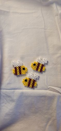 three small lego bees on a white sheet