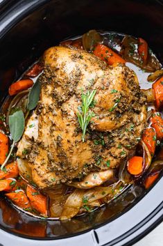 a chicken in a slow cooker with carrots and sage