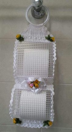 two white trays with flowers on them hanging from the wall next to a teapot