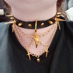 "Mortis" is an intricate, thought-provoking statement piece, featuring an ornate 1-inch crow skull pendant, 4 small cross charms, and a tiny bell to represent the old practice of safety coffins. It's the perfect addition to any punk, goth or grunge outfit, sure to help make you the life of the party (or make it rain compliments at the mall ;] ). The choker in the photos is 16 inches long, with 4 buckle settings at .75 inch spacing. The largest setting is 15.75 inches, and the smallest is 13.5 inches. You are welcome (and encouraged!) to request custom measurements, as these are entirely handmade and can be made to order. Sizing note: The preset options listed are for the MAX size setting. For example, if you order a 20 inch choker, the largest setting will be 20 inches, and the smallest wi Gothic Metal Choker For Concerts, Alternative Metal Choker For Concerts, Edgy Metal Choker For Halloween, Alternative Metal Choker For Halloween, Edgy Choker For Halloween Festival, Edgy Halloween Festival Choker, Gothic Choker For Concert, Gothic Choker For Halloween Concert, Alternative Festival Choker Jewelry