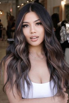 This hairstyle features cascading waves that create a dynamic contrast against the dark base with their heavy, ash-blonde highlights. The highlights are strategically placed to frame the face, accentuating the cheekbones and adding a bold yet refined touch to the overall look. It's an ideal choice for those with dark hair who want - Click to see more of 35 Glamorous Dark Hair Makeovers with Bold Highlight Accents and follow us for more hairstyle ideas. // Photo Credit: Instagram @glamourbycee Dark Hair Subtle Money Piece, Cool Highlights On Dark Hair Brunettes, Dark Hair Ash Balayage, Black To Ash Blonde Balayage, Cool Brown Highlights On Dark Hair, Dark Highlights On Black Hair, Dark Brown Hair With Ash Blonde Highlights, Black Money Piece Hair, Lowlights On Dark Hair