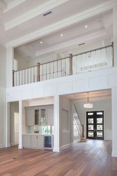 an empty living room with hardwood floors and white walls