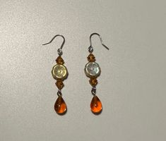 Handmade dangle earrings made with hand blown glass droplets, Czech flower beads, and Swarovski bicone beads Beaded Czech Glass Teardrop Earrings, Orange Teardrop Earrings With Dangling Beads, Teardrop Czech Glass Dangling Beads Earrings, Orange Faceted Beads Dangle Earrings, Beaded Glass Teardrop Earrings, Glass Beaded Teardrop Earrings, Teardrop Beaded Glass Earrings, Orange Teardrop Beaded Earrings, Handmade Teardrop Czech Glass Crystal Earrings