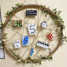 a wheel made out of branches with magnets and numbers on it, hanging from the wall