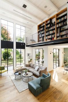 a living room filled with lots of furniture next to a tall book shelf full of books