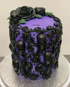 a purple and black cake with skulls on it