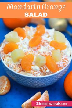 mandarin orange salad in a blue bowl surrounded by tangerines