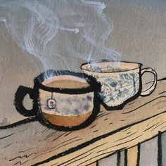 two coffee mugs sitting on top of a wooden table with steam rising from them