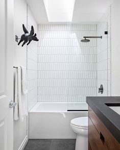 a bathroom with a white toilet and bathtub next to a black counter top sink