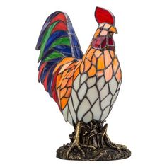 a stained glass rooster sitting on top of a tree stump