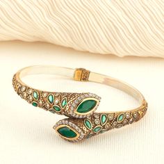 Introducing our exquisite Vintage Emerald Bangle -- a fusion of classic craftsmanship and modern elegance. Handcrafted with 925 Sterling Silver and Bronze, this boho-inspired cuff bracelet features green simulated gemstones that shimmer with vibrant beauty. ★ Premium Materials: Made with a blend of 925 sterling silver and bronze for durability and a luxurious finish. ★ Simulated Stone Details: This statement piece boasts simulated greenemerald gemstones cut in a marquise shape, symbolizing renew Luxury Antique Gold Bracelet With Intricate Design, Luxury Handmade Antique Style Bracelets, Luxury Antique Bangle Cuff Bracelet, Gemstone Cuff Bracelet, Custom Bangle, Jewelry Antique, Boho Luxe, Bracelet Boho, Bangle Designs