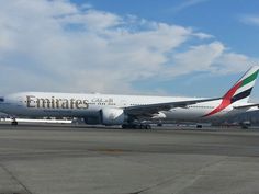 an emirates airliner sitting on the tarmac at an airport