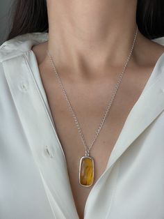 This stylish sterling silver pendant with a natural amber stone is sure to delight. Crafted from high-quality silver and featuring an 19-inch length chain, this jewelry piece is perfect for adding a touch of sophistication to your look. Silver Amber Jewelry, Amber Pendant Necklace In Baltic Amber, Baltic Amber Pendant Necklace, Pendant Citrine Necklace With Polished Finish, Polished Citrine Pendant Necklace, Polished Amber Citrine Necklace, Elegant Yellow Baltic Amber Necklaces, Baltic Amber Necklaces As Gifts, Amber Necklace With Large Oval Pendant