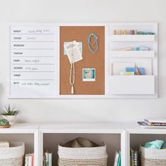 there is a bulletin board and baskets on the wall in this room with white walls