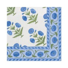 a blue and green flowered napkin on a white tablecloth with an embroidered border