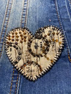 a heart made out of old jeans with beads and sequins in the back pocket