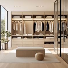 a walk in closet filled with lots of clothes and furniture next to a large window