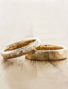 two gold wedding bands with diamonds on them