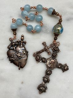 This is a beautiful, wire-wrapped, heirloom single decade rosary! The rosary is handmade with 20 gauge bronze wire. The medals and crucifix are all bronze.  The beads are 8mm Aquamarine and 10mm tensha bead.  The Rosary is the most excellent form of prayer and the most efficacious means of attaining eternal life. It is the remedy for all our evils, the root of all our blessings. There is no more excellent way of praying.~Pope Leo XIII Handmade Bronze Spiritual Rosary, Handmade Spiritual Bronze Rosary, Spiritual Gift Wire Wrapped Rosary, Handmade Bronze Rosary As A Gift, Spiritual Wire Wrapped Rosary As Gift, Pope Leo Xiii, Pope Leo, Immaculate Heart, Decade Rosary