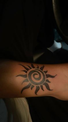 a person's arm with a tattoo on it and the sun in the middle