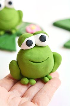 a close up of a person holding a toy frog