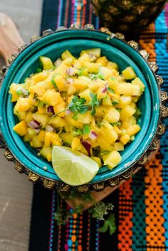 a blue bowl filled with pineapple salsa on top of a table