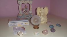 an angel statue sitting on top of a table next to some rocks and other items